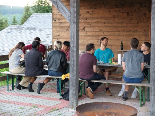 The group at picnic tables outside a mountain hut